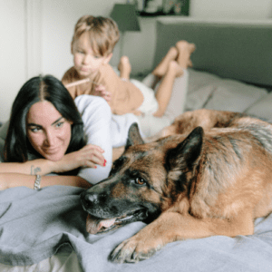 Brownish German Shepherd with a mommy and a toddle kid in the bed